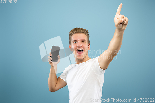 Image of Caucasian young man\'s half-length portrait on blue background