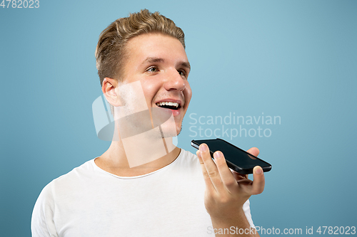 Image of Caucasian young man\'s half-length portrait on blue background