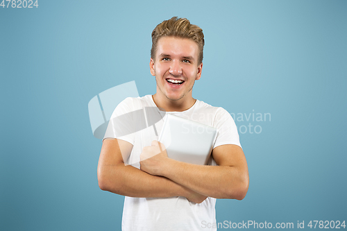 Image of Caucasian young man\'s half-length portrait on blue background