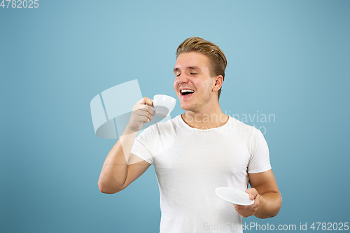 Image of Caucasian young man\'s half-length portrait on blue background