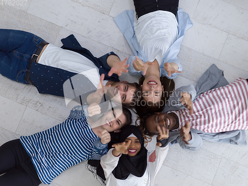 Image of top view of a diverse group of people lying on the floor and symbolizing togetherness