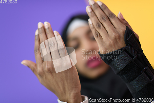 Image of african muslim woman wearing hijab and traditional muslim clothes posing in front of green background