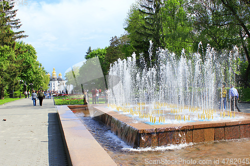 Image of People have a rest in city park with fountains