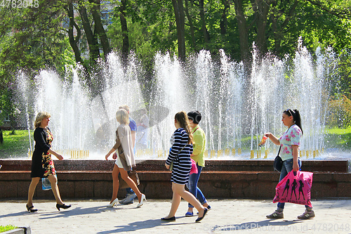 Image of women have a rest in city park with fountains