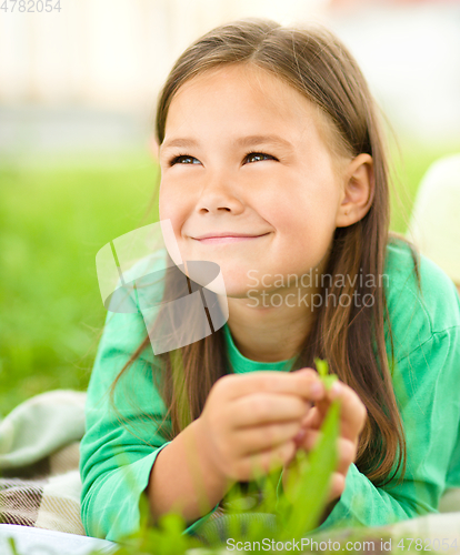 Image of Portrait of a little girl laying on green grass