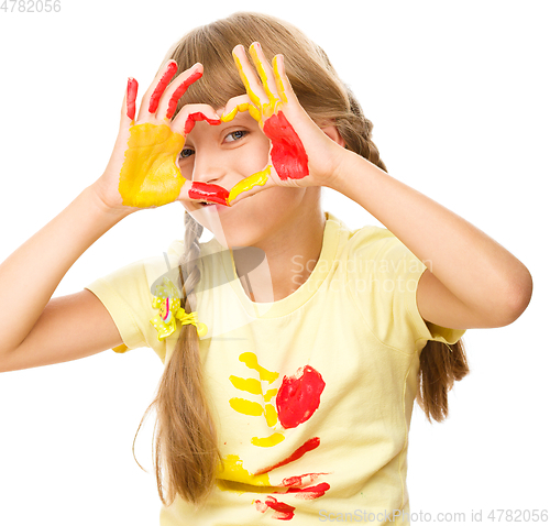 Image of Portrait of a cute girl playing with paints