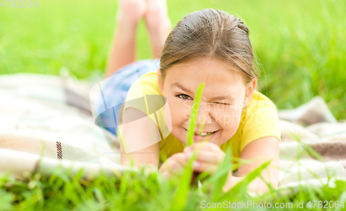 Image of Portrait of a little girl laying on green grass
