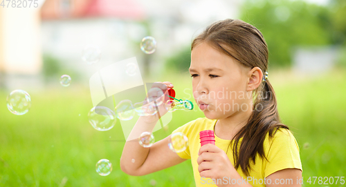 Image of Little girl is blowing a soap bubbles