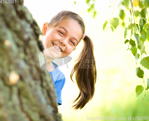 Image of Cute little girl is playing hide and seek