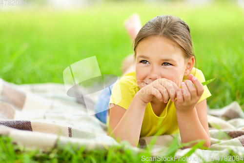 Image of Portrait of a little girl laying on green grass