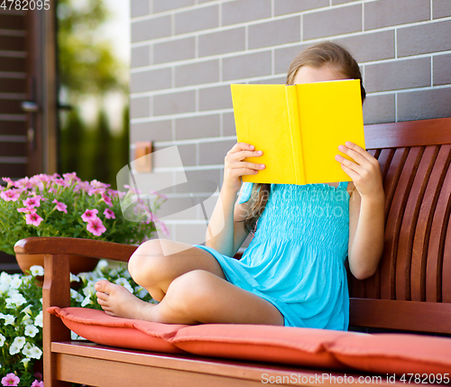 Image of Little girl is reading a book