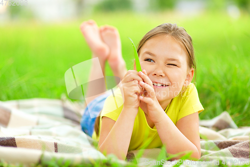 Image of Portrait of a little girl laying on green grass