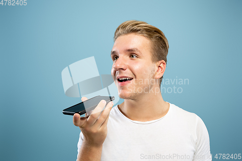 Image of Caucasian young man\'s half-length portrait on blue background