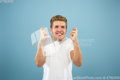 Image of Caucasian young man\'s half-length portrait on blue background