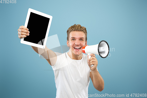 Image of Caucasian young man\'s half-length portrait on blue background