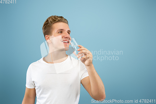 Image of Caucasian young man\'s half-length portrait on blue background