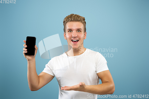 Image of Caucasian young man\'s half-length portrait on blue background