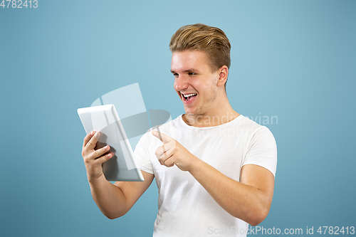 Image of Caucasian young man\'s half-length portrait on blue background