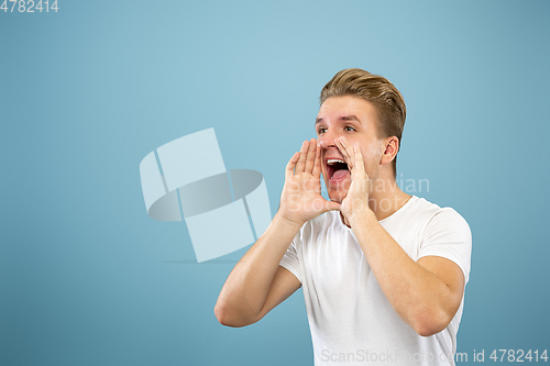 Image of Caucasian young man\'s half-length portrait on blue background