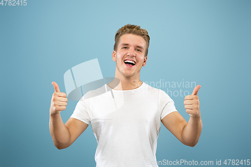 Image of Caucasian young man\'s half-length portrait on blue background