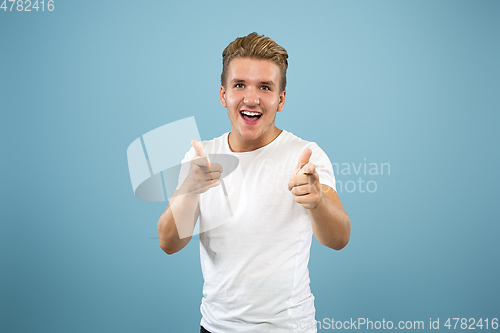 Image of Caucasian young man\'s half-length portrait on blue background