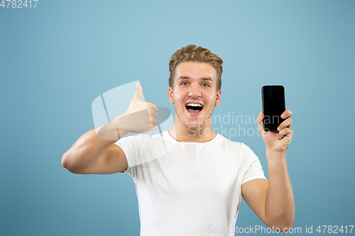 Image of Caucasian young man\'s half-length portrait on blue background