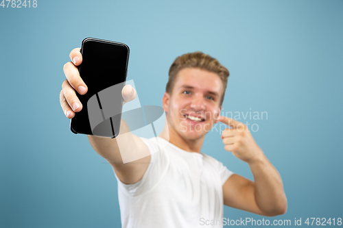 Image of Caucasian young man\'s half-length portrait on blue background