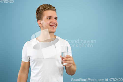 Image of Caucasian young man\'s half-length portrait on blue background
