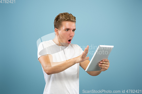 Image of Caucasian young man\'s half-length portrait on blue background