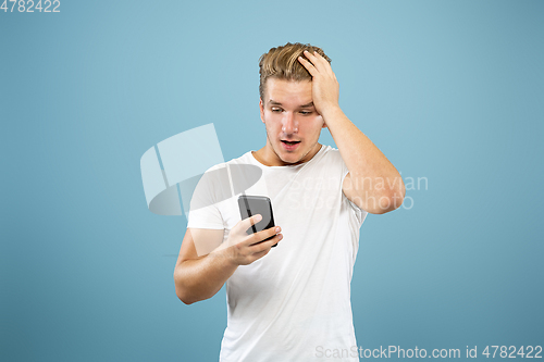 Image of Caucasian young man\'s half-length portrait on blue background