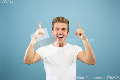 Image of Caucasian young man\'s half-length portrait on blue background