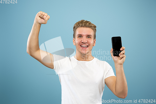 Image of Caucasian young man\'s half-length portrait on blue background