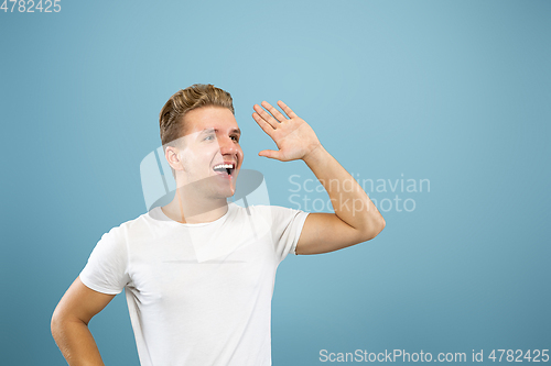 Image of Caucasian young man\'s half-length portrait on blue background