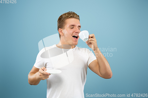 Image of Caucasian young man\'s half-length portrait on blue background