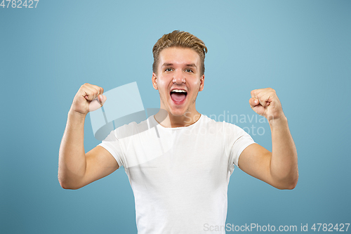Image of Caucasian young man\'s half-length portrait on blue background