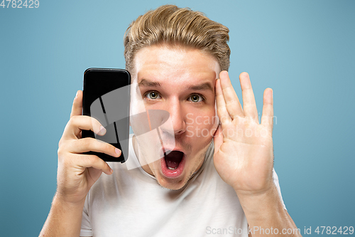 Image of Caucasian young man\'s half-length portrait on blue background