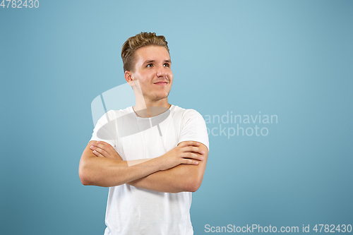 Image of Caucasian young man\'s half-length portrait on blue background