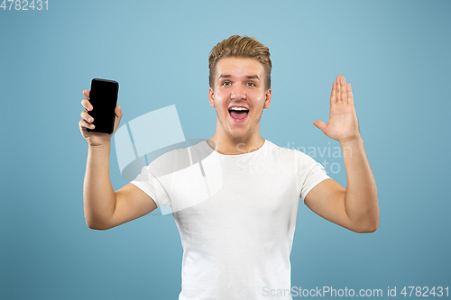 Image of Caucasian young man\'s half-length portrait on blue background