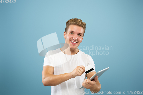 Image of Caucasian young man\'s half-length portrait on blue background