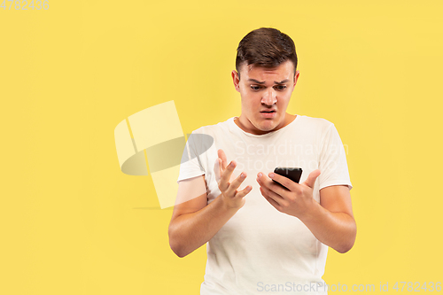 Image of Caucasian young man\'s half-length portrait on yellow background