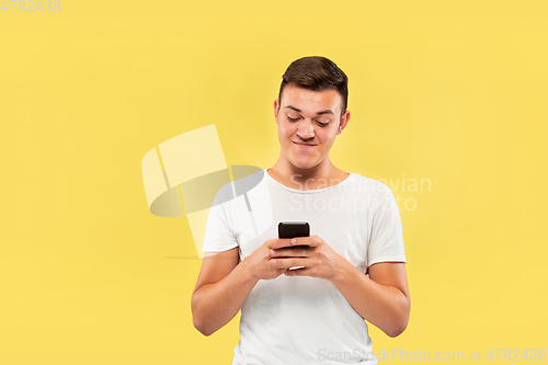 Image of Caucasian young man\'s half-length portrait on yellow background