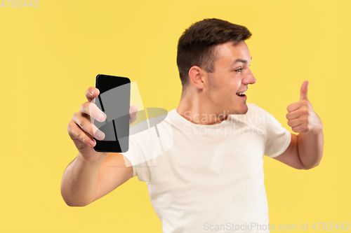 Image of Caucasian young man\'s half-length portrait on yellow background