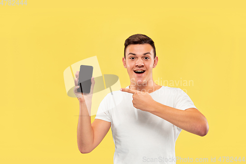 Image of Caucasian young man\'s half-length portrait on yellow background