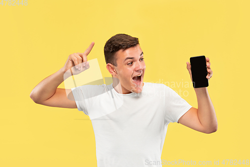 Image of Caucasian young man\'s half-length portrait on yellow background