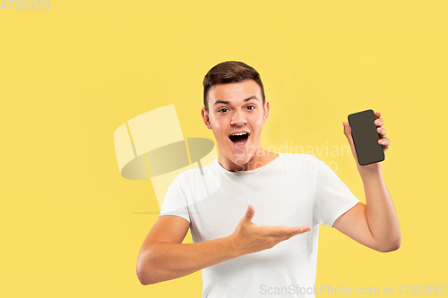 Image of Caucasian young man\'s half-length portrait on yellow background