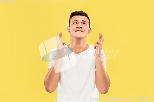 Image of Caucasian young man\'s half-length portrait on yellow background