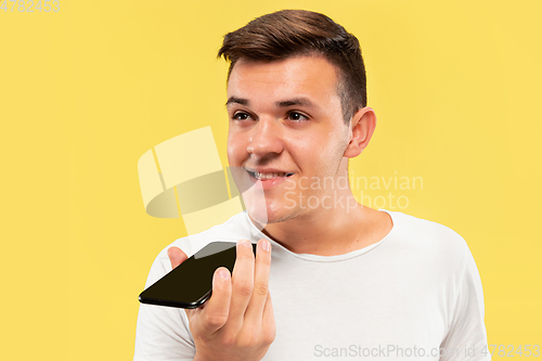 Image of Caucasian young man\'s half-length portrait on yellow background