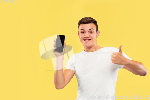 Image of Caucasian young man\'s half-length portrait on yellow background