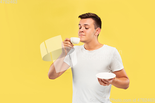 Image of Caucasian young man\'s half-length portrait on yellow background