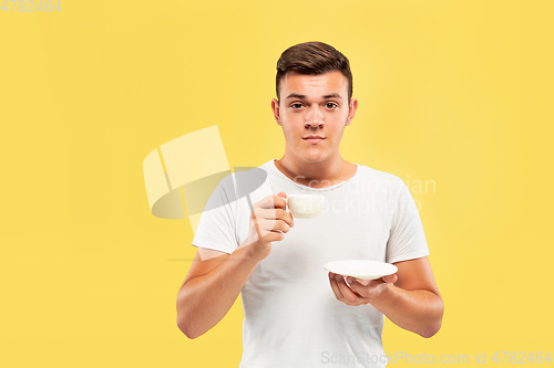 Image of Caucasian young man\'s half-length portrait on yellow background